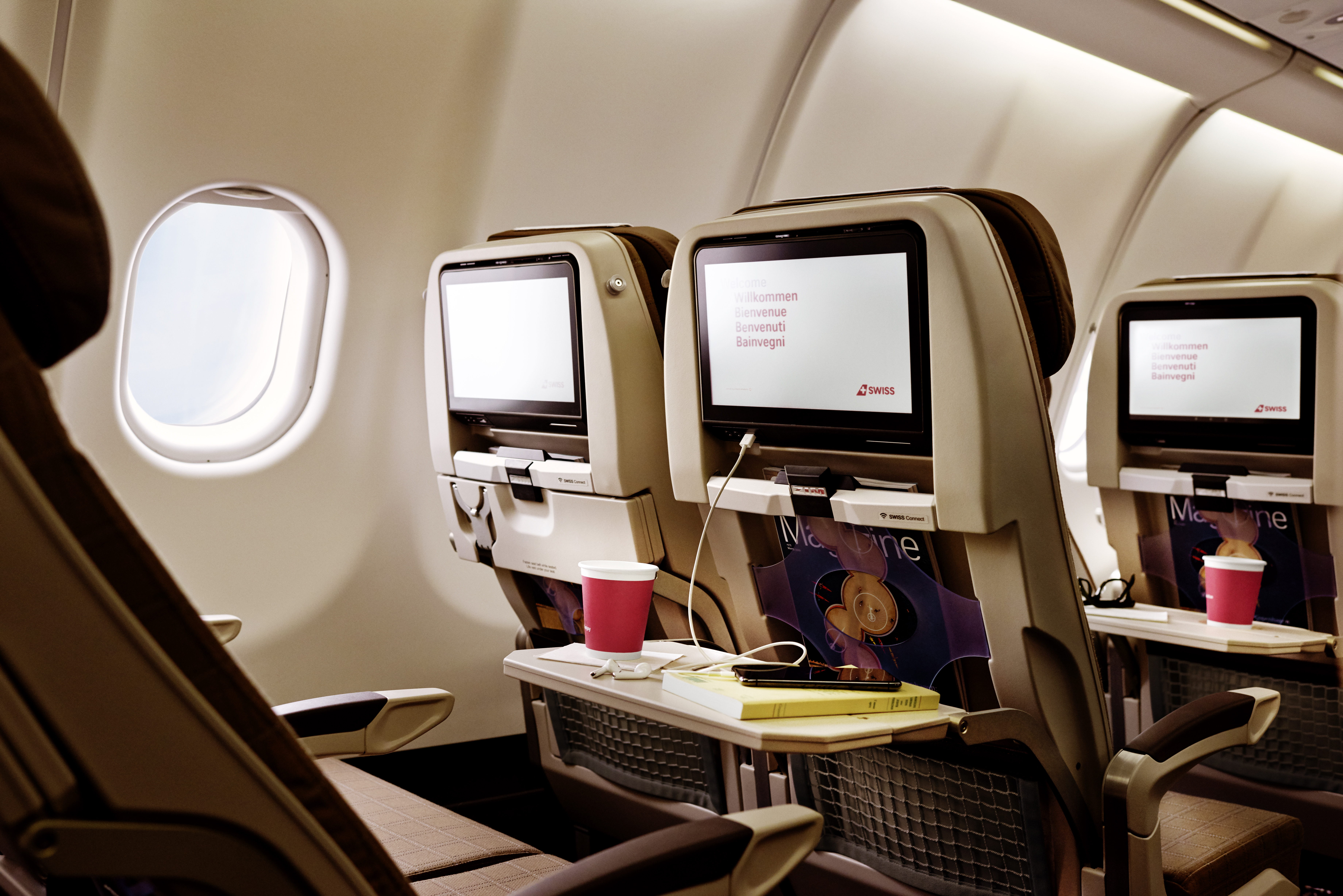 Airplane seats with in-flight entertainment screens.
