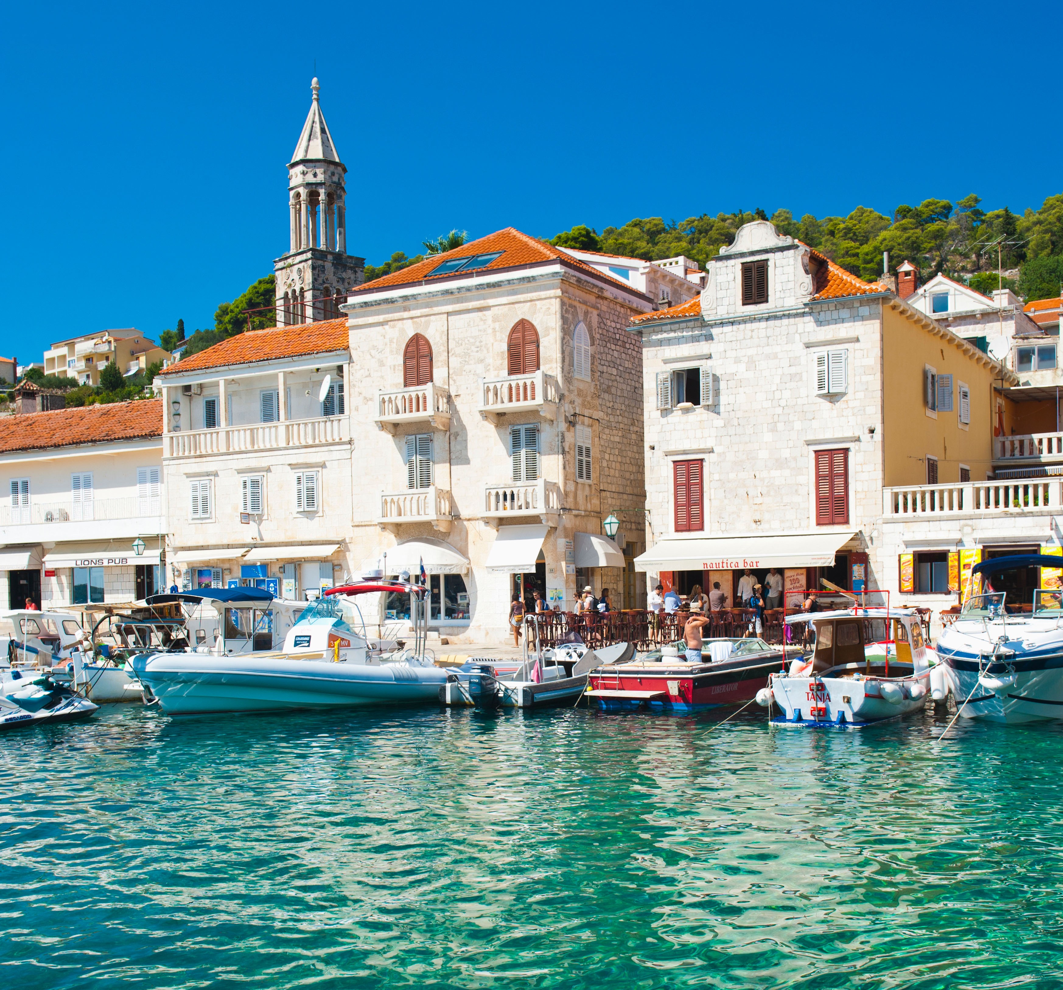Hvar town harbor in Croatia with boats and clear water.