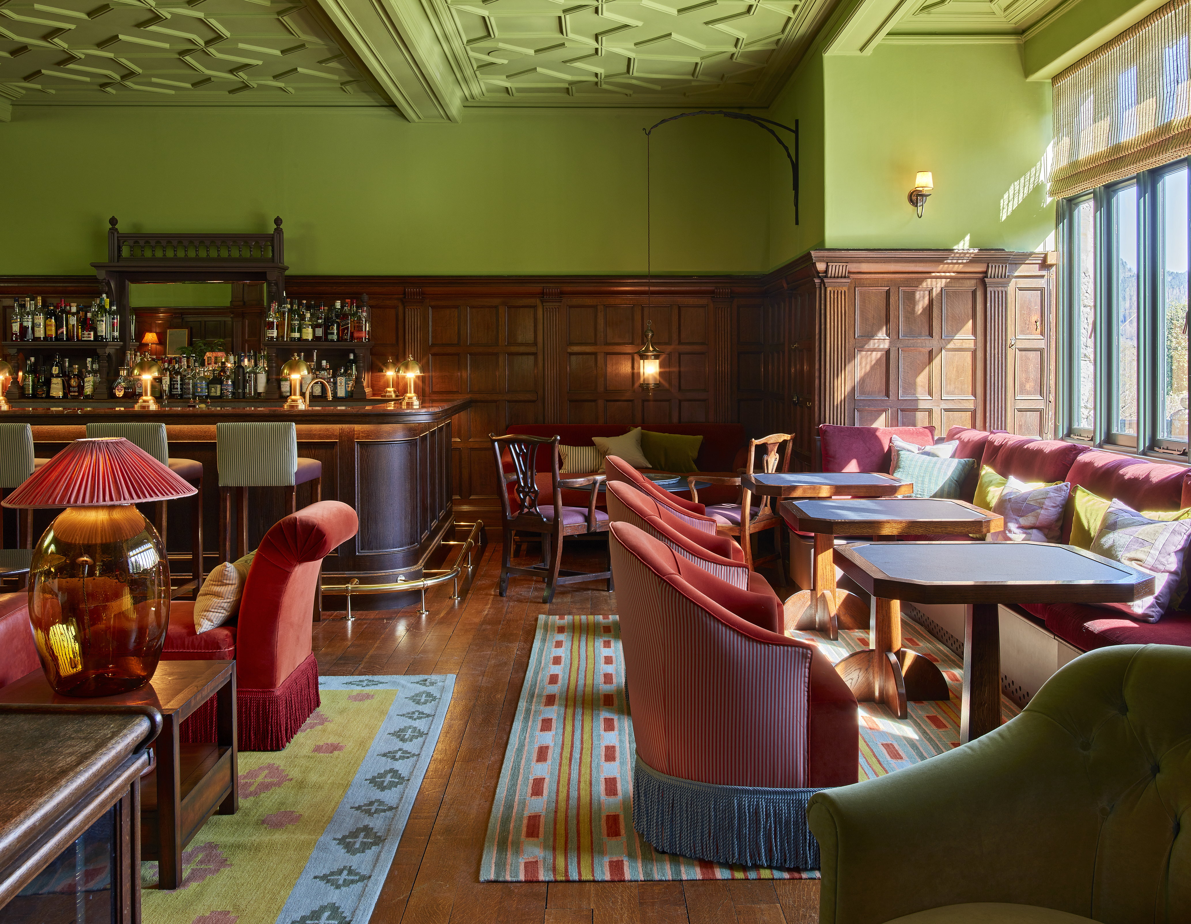 Stylish bar area with red and green furnishings.