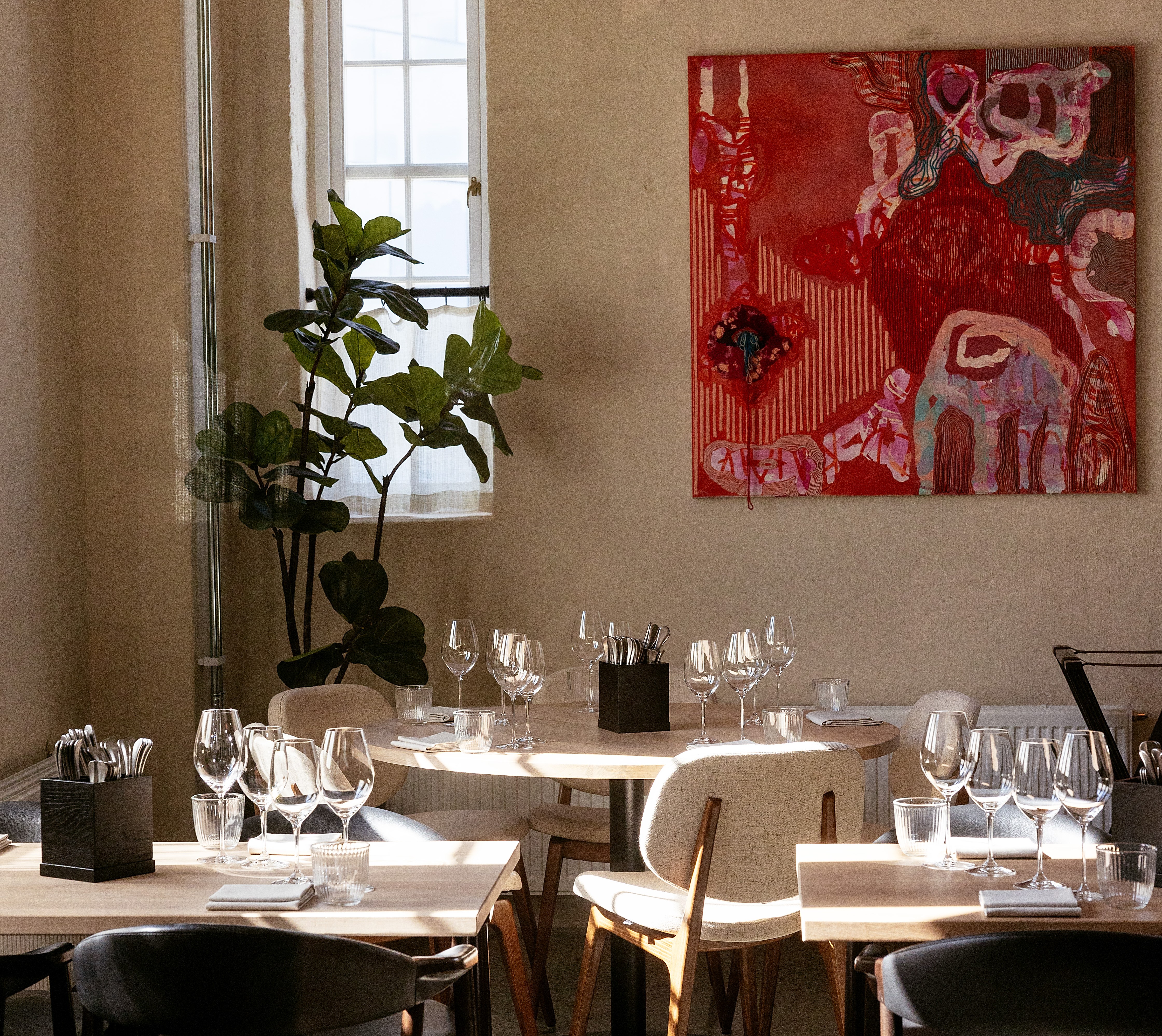 Interior of Tollbua restaurant in Trondheim, Norway, showing tables set for diners.