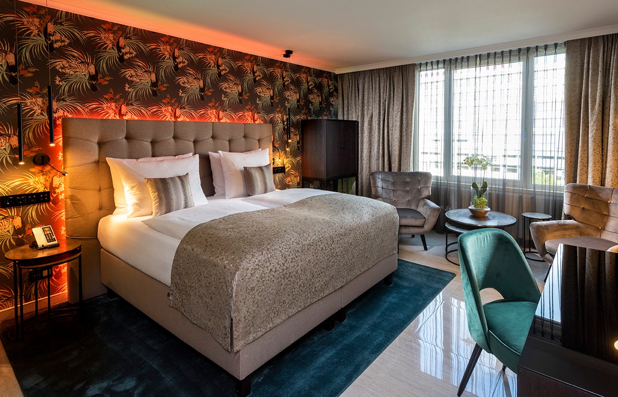 Hotel Palace Berlin room featuring a large bed, seating area, and desk.