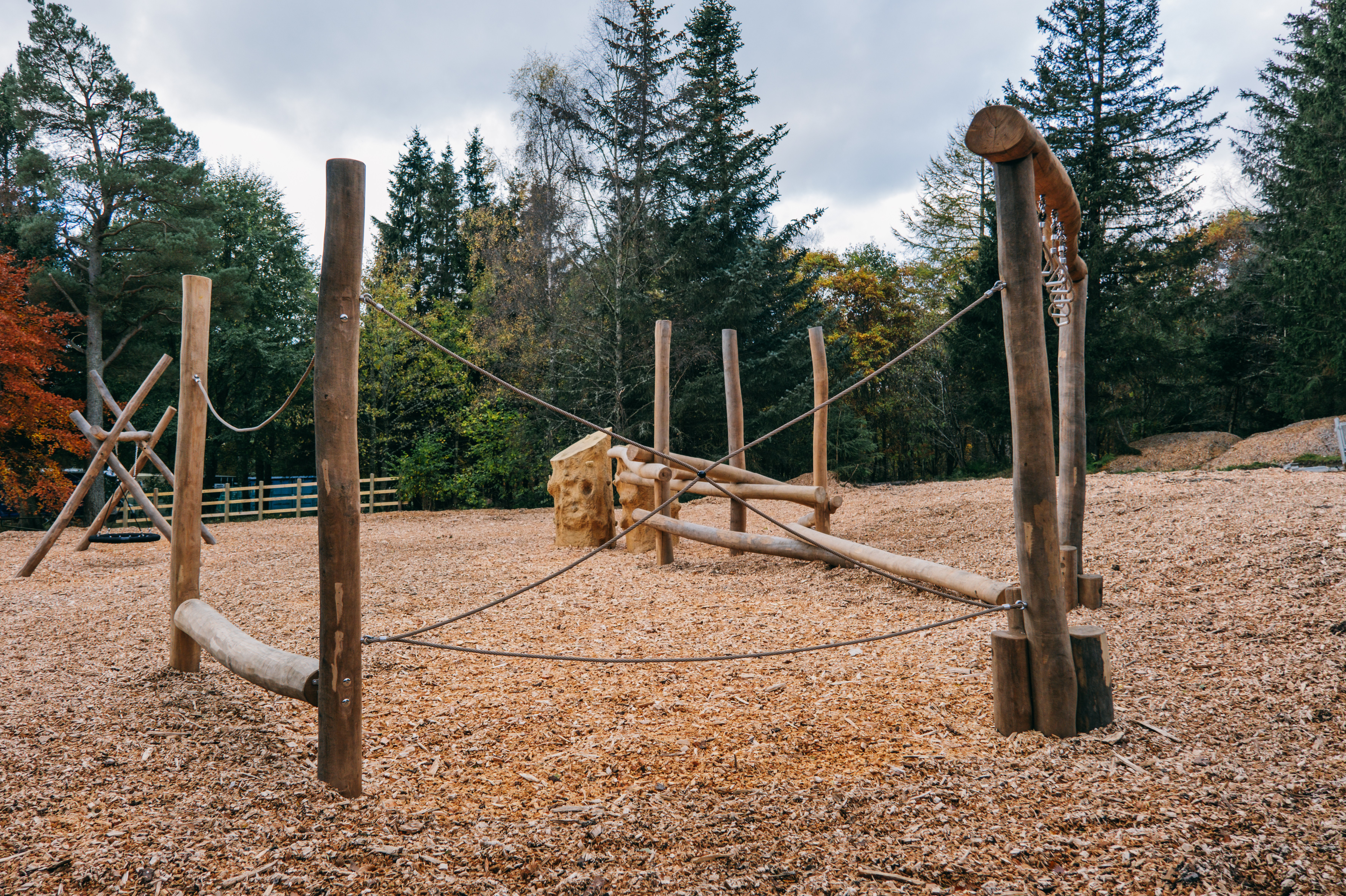 Wooden playground equipment in a forest.