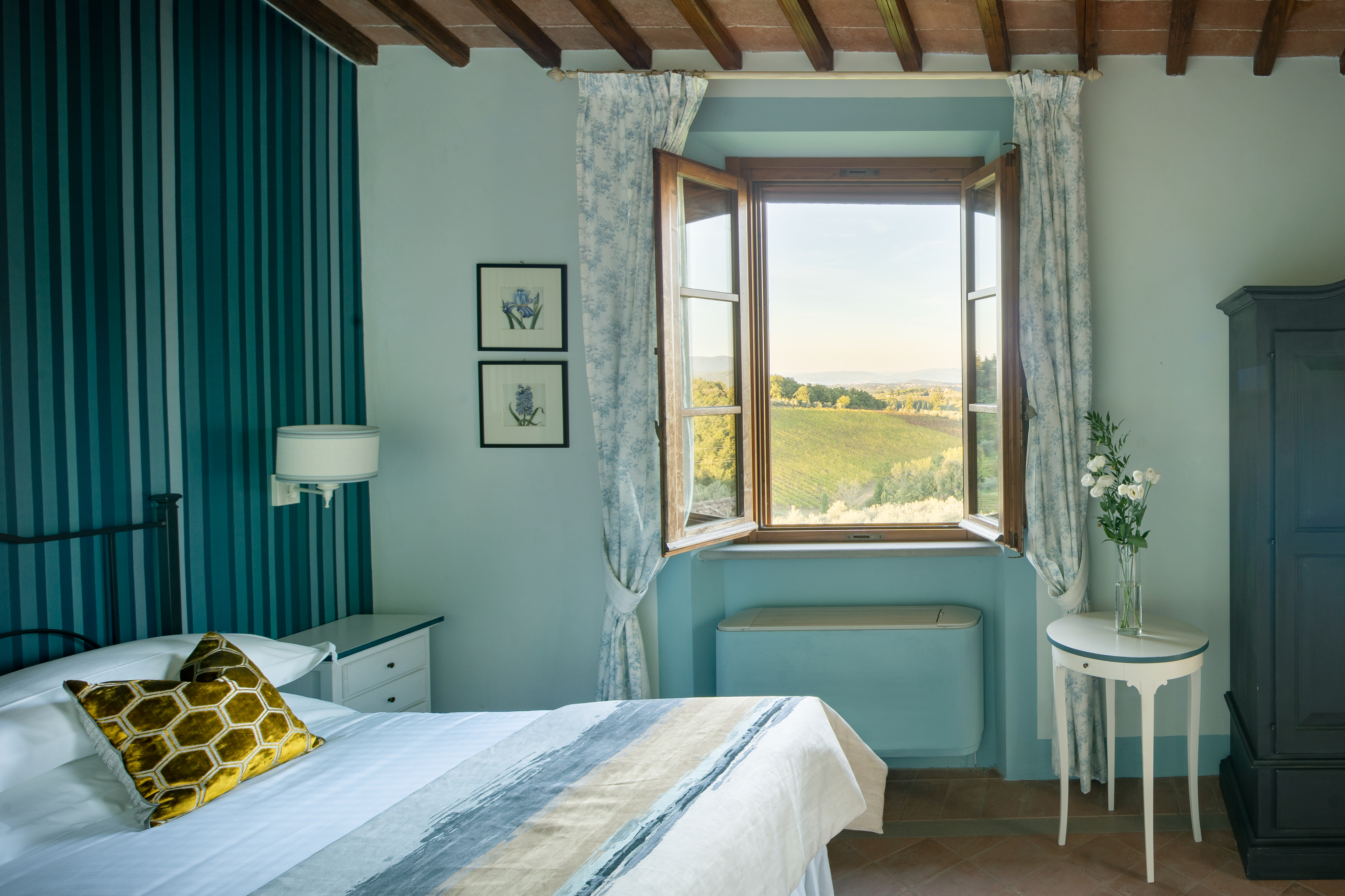 An open window looks out onto countryside from a bedroom at Villa Chiantisol, Tavarnelle Val di Pesa, Tuscany, one of the best villas in Italy with a pool