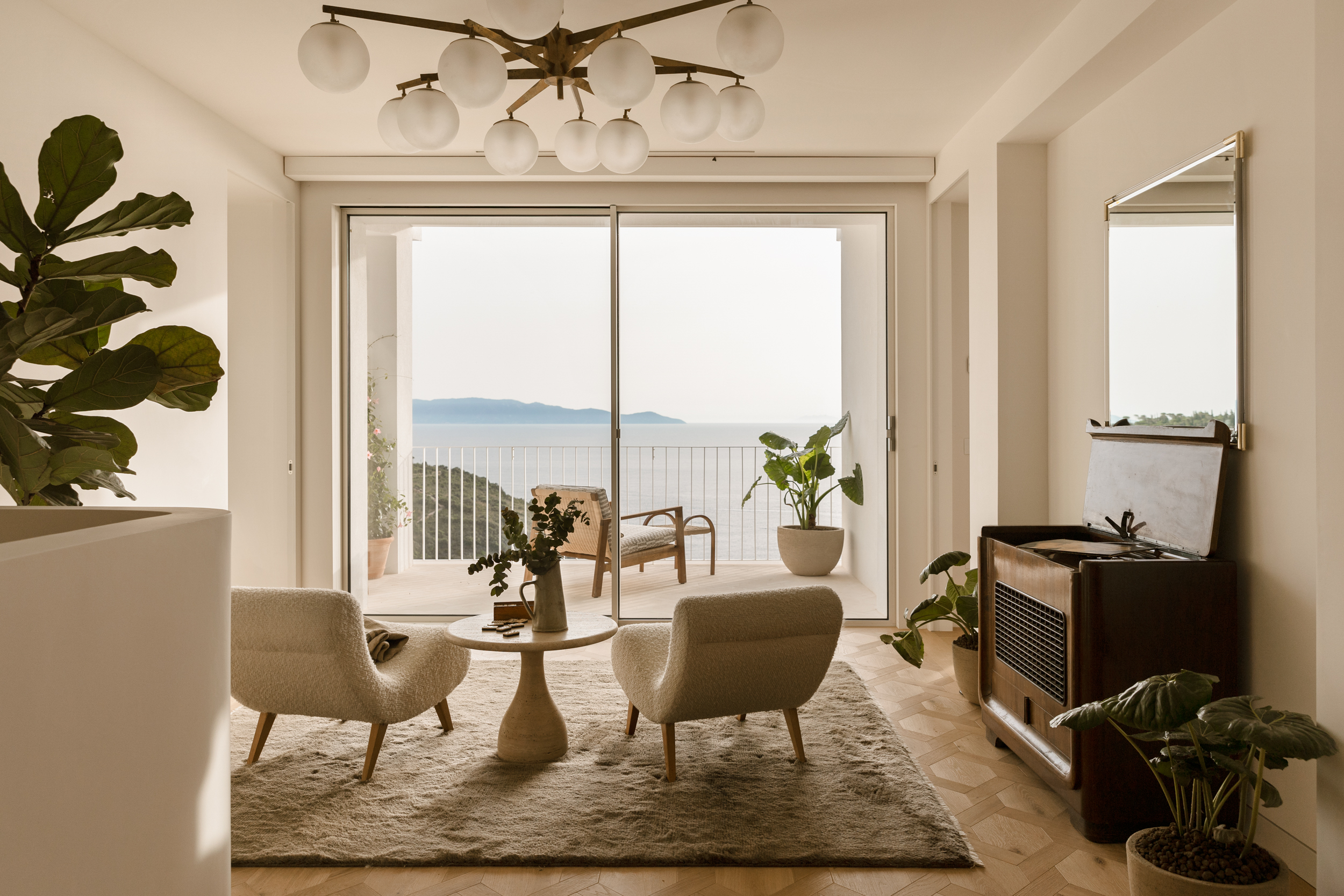 An antique record player and seats facing towards a patio door at Villa Cacciarella, Monte Argentario, Tuscany, one of the best villas in Italy with a pool