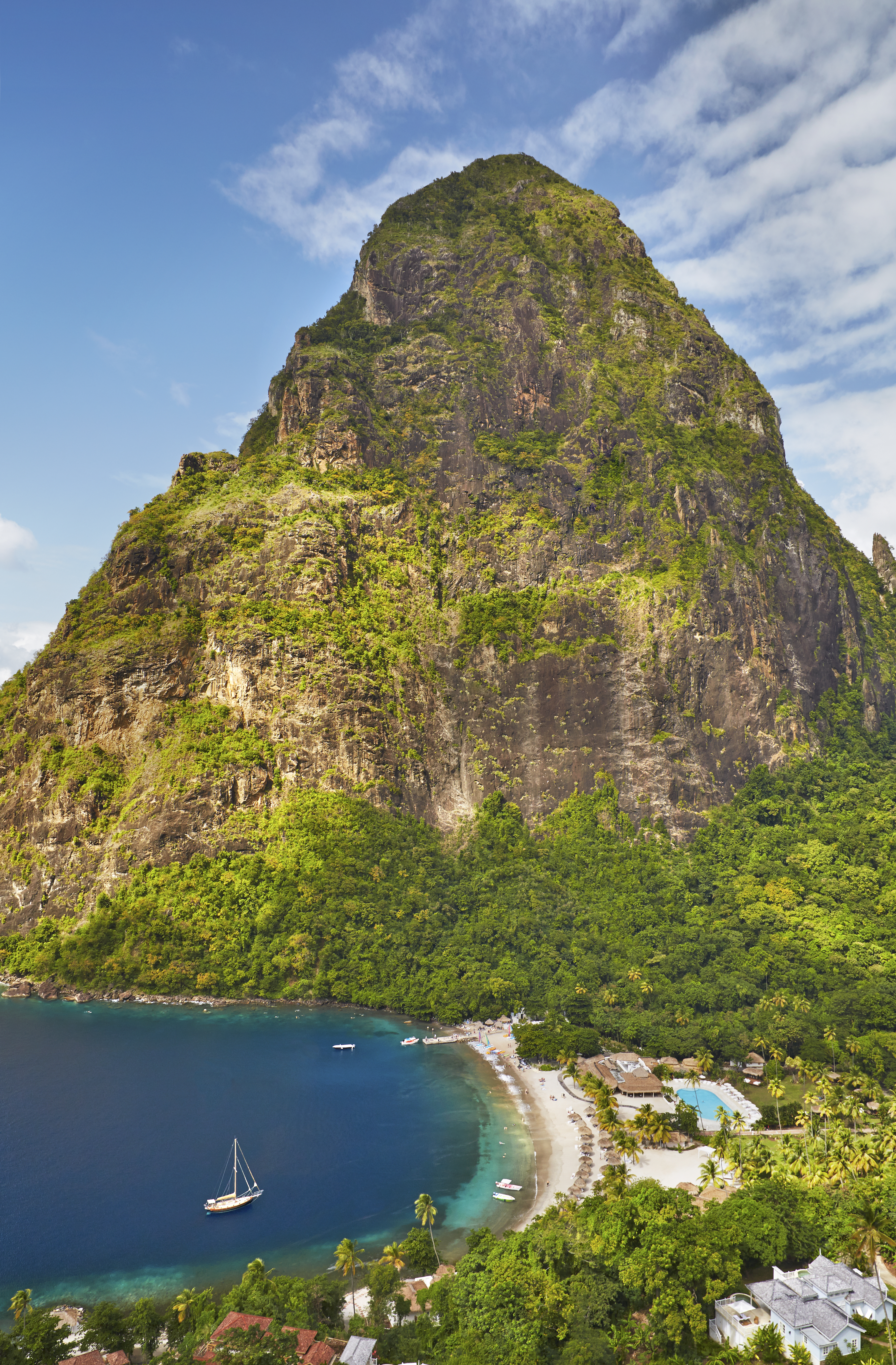 Aerial view of Sugar Beach, St. Lucia, with a large mountain in the background.