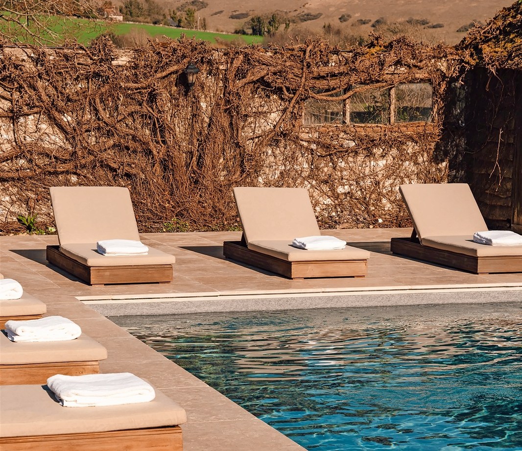 Alfriston poolside lounge chairs with towels.